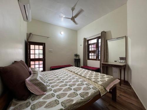 um quarto com uma cama, uma mesa e 2 janelas em Param Country Home With Pool em Jalandhar