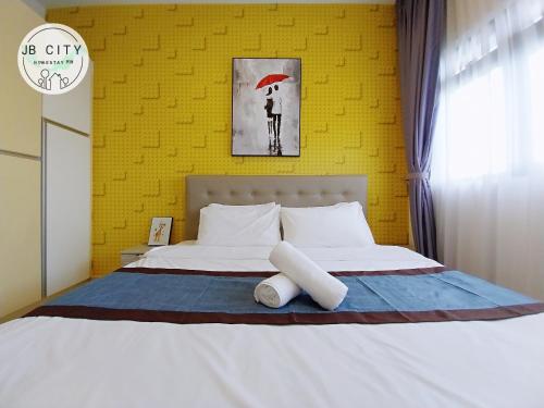 a bedroom with a white bed with a yellow wall at Pangsapuri Meridian by RR JBcity in Nusajaya