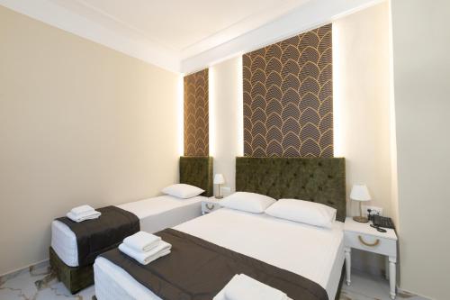 a hotel room with two beds and a desk at Modern Revival Luxury Hotel in Thessaloniki