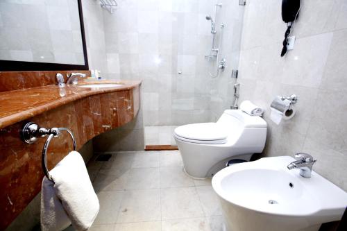a bathroom with a white toilet and a sink at Musherib Hotel in Doha