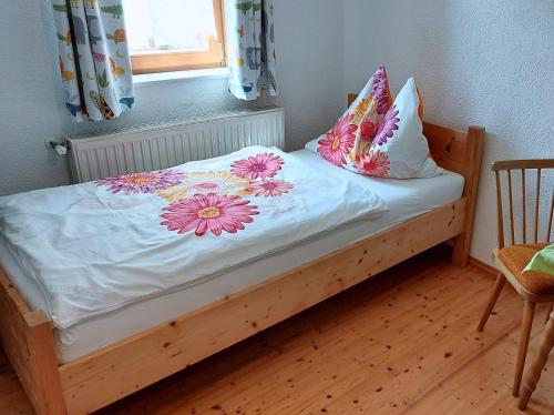 Una cama con flores en ella con una ventana en Malerisches Bauernhaus, en Lieserhofen
