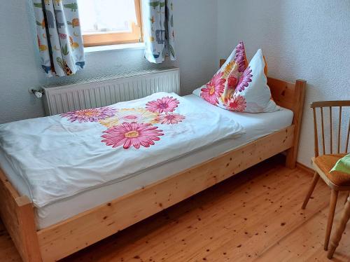 un letto con fiori sopra con finestra di Malerisches Bauernhaus a Lieserhofen