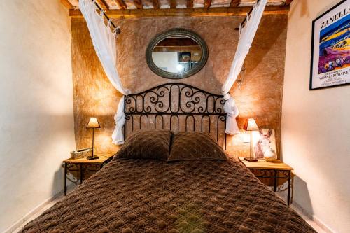 Le Lavandin في Clansayes: غرفة نوم بسرير كبير مع مرآة