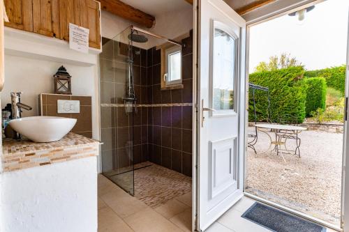 baño con ducha, lavabo y puerta en Le Lavandin, en Clansayes