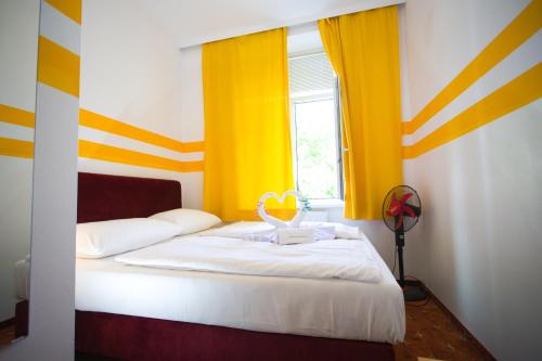 Schlafzimmer mit einem Bett mit gelben und weißen Streifen in der Unterkunft Hotel City Residence in Wien