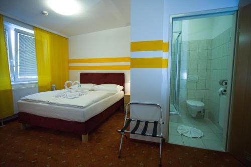 a bedroom with a bed and a shower and a toilet at Hotel City Residence in Vienna