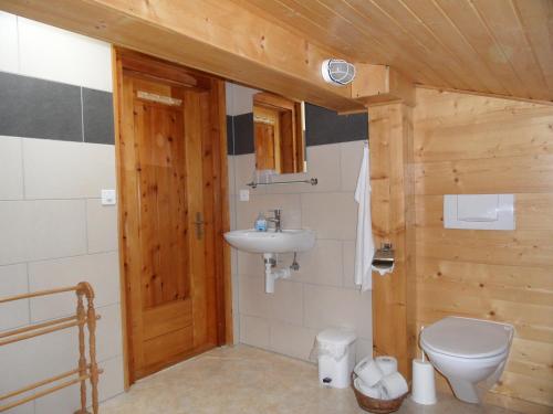 a bathroom with a toilet and a sink at Chalet Esher Surrey in Ried-Brig