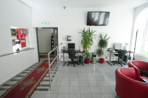 an office with chairs and desks and a tv on the wall at Hotel City Residence in Vienna