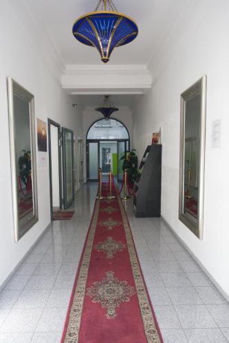 a hallway with a red carpet and a chandelier at Hotel City Residence in Vienna
