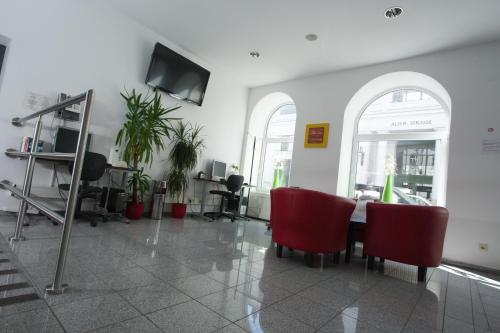 a dining room with red chairs and a table at Hotel City Residence in Vienna