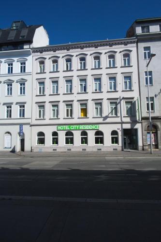 a large white building with a sign on it at Hotel City Residence in Vienna