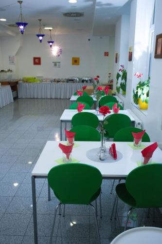 a room with green chairs and tables with flowers on them at Hotel City Residence in Vienna