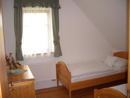 a small bedroom with a bed and a window at Doubické chalupy in Doubice