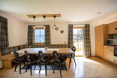 オルティゼーイにあるSchoenau Bio & SPA Family Apartmentsのキッチン、ダイニングルーム(木製のテーブルと椅子付)