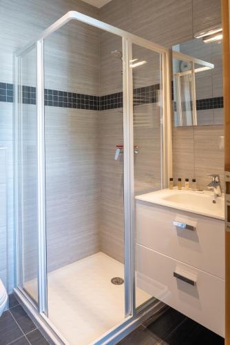 une salle de bain avec douche et lavabo dans l'établissement Apartment Les Alpages, aux Gets