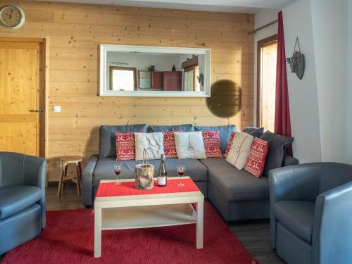 salon z niebieską kanapą i stołem w obiekcie Apartment Les Alpages w mieście Les Gets