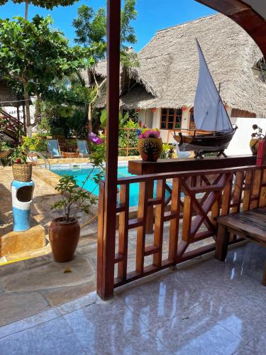 a model boat on a table next to a pool at Utulivu Bungalow in Nungwi