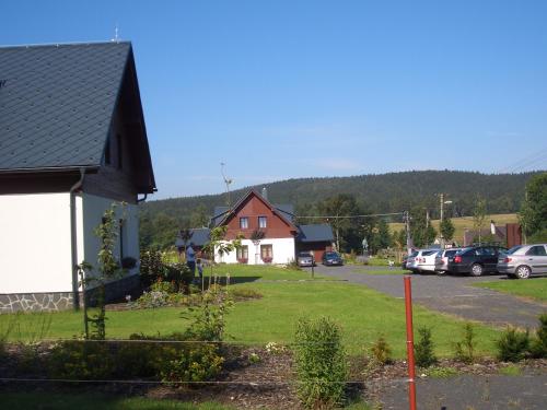 a house with a lot of cars parked in a parking lot at Doubické chalupy in Doubice