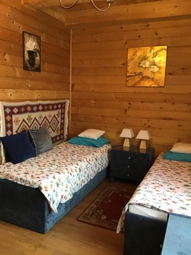 2 łóżka w pokoju z drewnianymi ścianami w obiekcie Jankówka w Wieliczce
