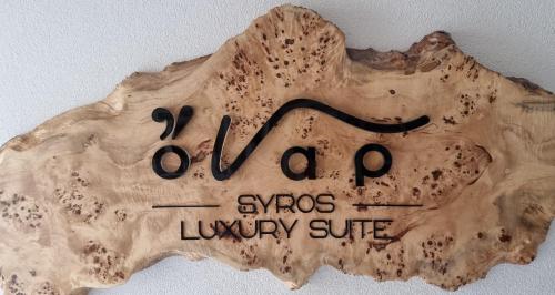 a wooden sign with the words super luxury suite at ONAR LUXURIES in Ermoupoli