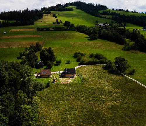 an aerial view of a green field with a house at Chata nad Termami VIP in Dzianisz