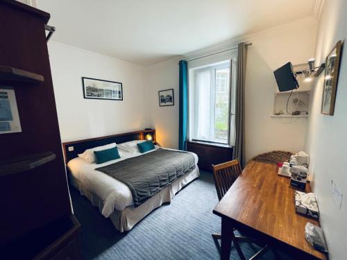 une chambre d'hôtel avec un lit, une table et une fenêtre dans l'établissement Quic En Groigne, à Saint-Malo