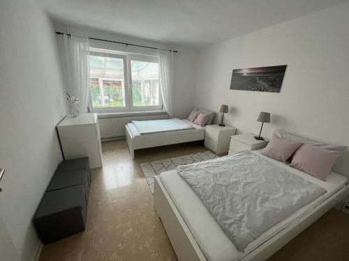 a white bedroom with a bed and a couch at Familienfreundliche Ferienwohnung mit Wintergarten in Badow