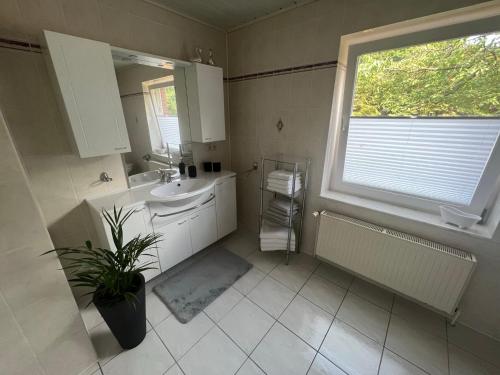 a bathroom with a sink and a window at Familienfreundliche Ferienwohnung mit Wintergarten in Badow
