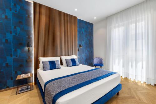 a bedroom with a bed and a blue wall at Dreamers' Rooms Sorrento in Sorrento