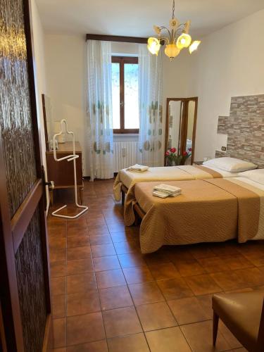 a hotel room with two beds and a window at Casa Caterina 2 storey house, with a mountain view in Toscolano Maderno