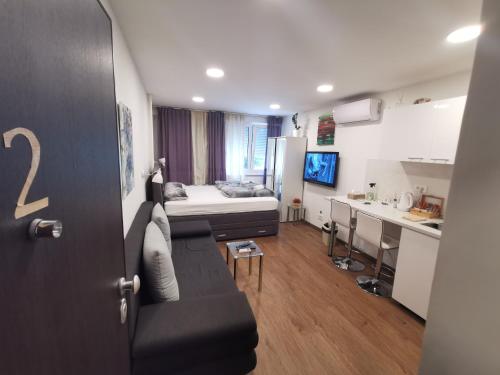 a small room with a bed and a kitchen at Apartment Novi Zagreb in Zagreb