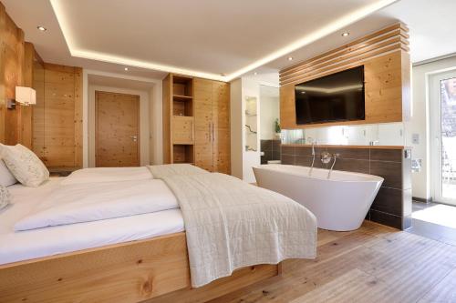 a bedroom with a bed and a tub and a television at Landhotel Schwab in Schwarzach am Main