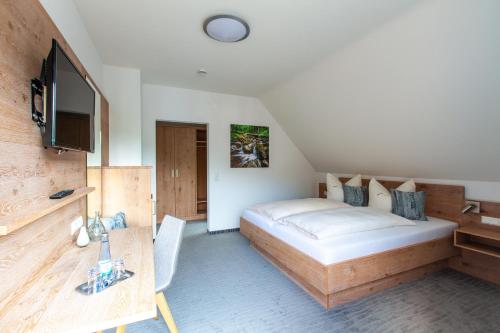 ein Hotelzimmer mit einem Bett und einem TV in der Unterkunft Gasthaus Rebstock in Simonswald