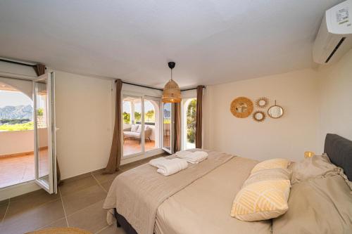 ein Schlafzimmer mit einem Bett und einem großen Fenster in der Unterkunft ROMERO - Managed by Almarina Villas in Benissa