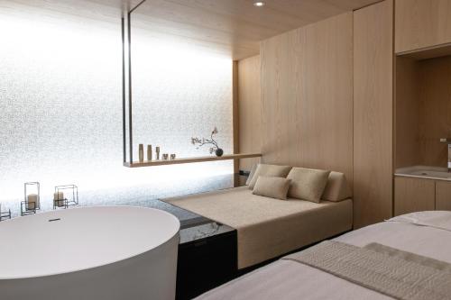 a room with two beds and a bathtub in it at Victoria Jungfrau Grand Hotel & Spa in Interlaken
