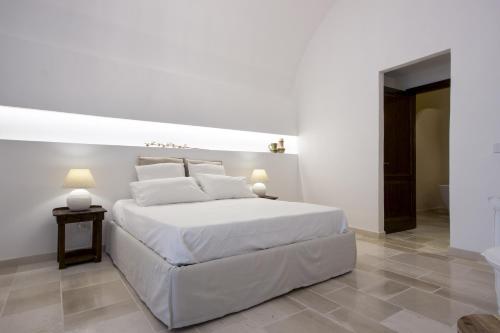 een witte slaapkamer met een groot wit bed en een tafel bij Anfora dei Segreti - Suite Apartment in Polignano a Mare