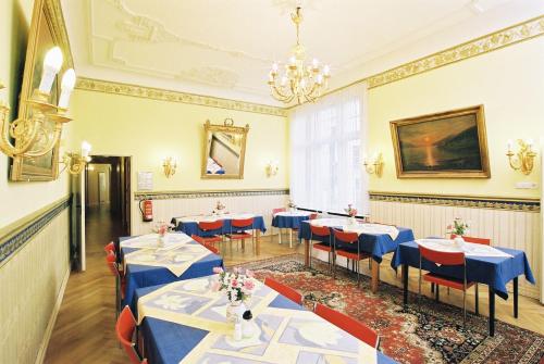 a dining room with blue tables and red chairs at Hotel Gunia in Berlin