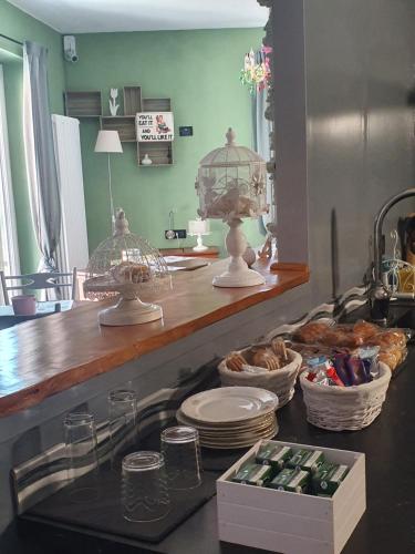 a kitchen with a counter with plates and birds cages at Il Giramondo in Busca
