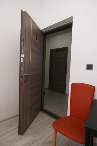 a room with a door and a red chair at Vurk INN Paracin in Paraćin