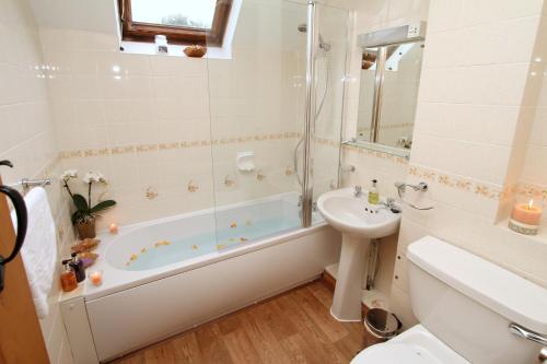 a bathroom with a tub and a sink and a toilet at Ratty's Retreat in Blockley