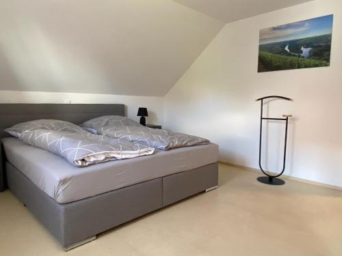 Un dormitorio con una cama y una lámpara. en Ferienwohnung am Holzberg in Volkach mit Weitblick, en Volkach