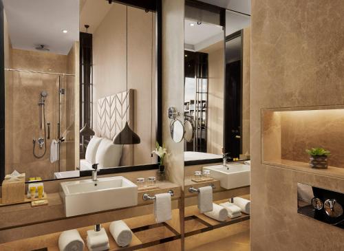 a bathroom with two sinks and two mirrors at Hyatt Centric Juhu Mumbai in Mumbai