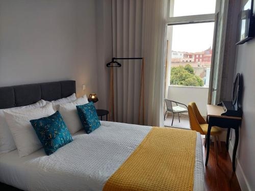 Un dormitorio con una cama con almohadas azules y una ventana en Cool Suites, en Oporto