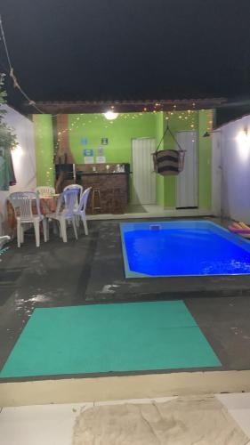 a pool in a room with a table and chairs at Casa com Ar e piscina no centro in Prado