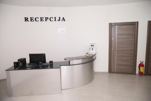 an office with a reception desk with a sign on the wall at Vurk INN Paracin in Paraćin