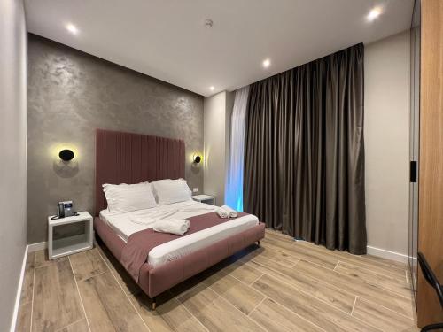 a bedroom with a bed and a large window at Domus Hotel & Apartments in Shëngjin