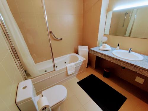 a bathroom with a tub and a toilet and a sink at Jardiv's Apart in Ponta Delgada
