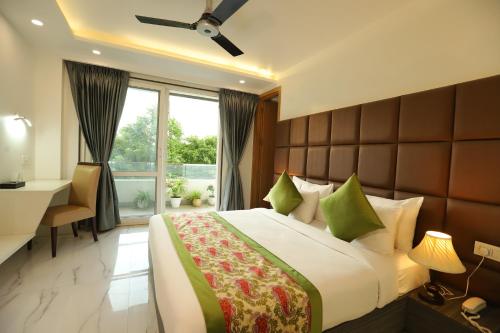 a bedroom with a bed and a desk and a window at Hotel Keshav Residency near Medanta Pure Veg in Gurgaon