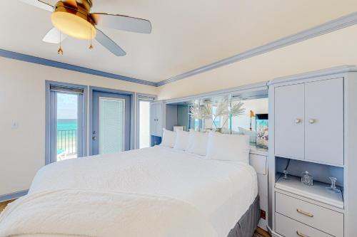 ein weißes Schlafzimmer mit einem Bett und einem Deckenventilator in der Unterkunft Costa Del Sol C1- Scenic Sands in Destin