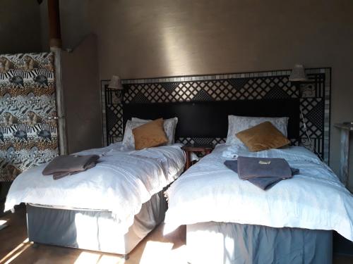 two beds sitting next to each other in a bedroom at African Silhouette Guesthouse in Benoni